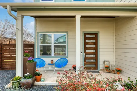 a view of a house with chair and flower potted plants