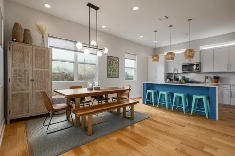 a living room with furniture a flat screen tv and kitchen view