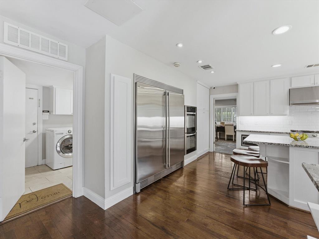 6160 Spring Valley Road Dallas, TX 75240 - Photo 9 of 40 Gourmet kitchen featuring wood-finish flooring, recessed lighting, double stainless steel refrigerator, and built-in double ovens