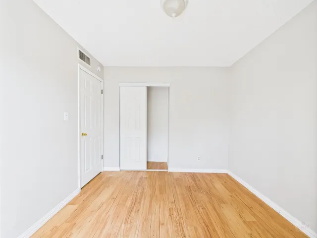 a view of empty room with wooden floor