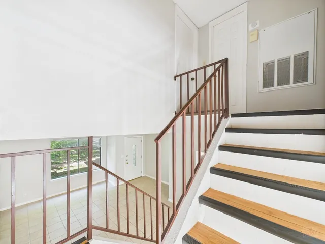a view of staircase with wooden floor and fan