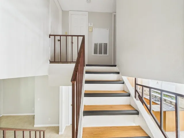 a view of staircase with white walls and a window