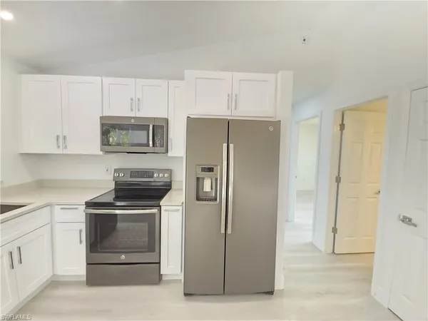 a kitchen with white cabinets and stainless steel appliances