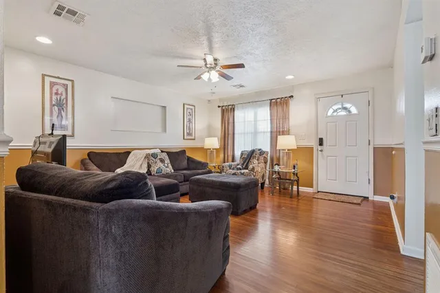 a living room with furniture and wooden floor