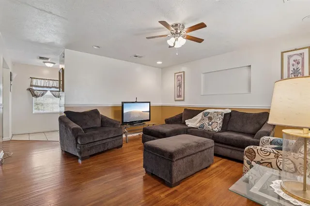 a living room with furniture and wooden floor