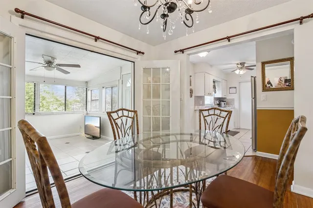 a dining room with furniture a chandelier and wooden floor