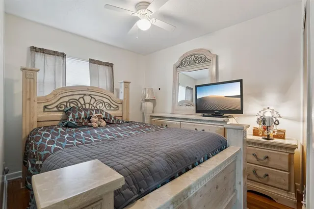 a bedroom with a large bed and a flat tv screen on dresser