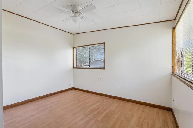 an empty room with a window and a ceiling fan