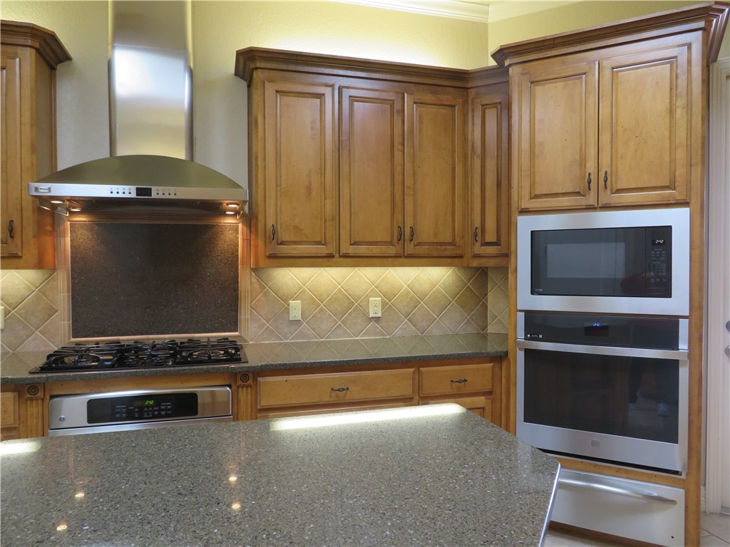 5803 South Oso Parkway Corpus Christi, TX 78414 - Photo 14 of 39 a kitchen with granite countertop a stove and a refrigerator