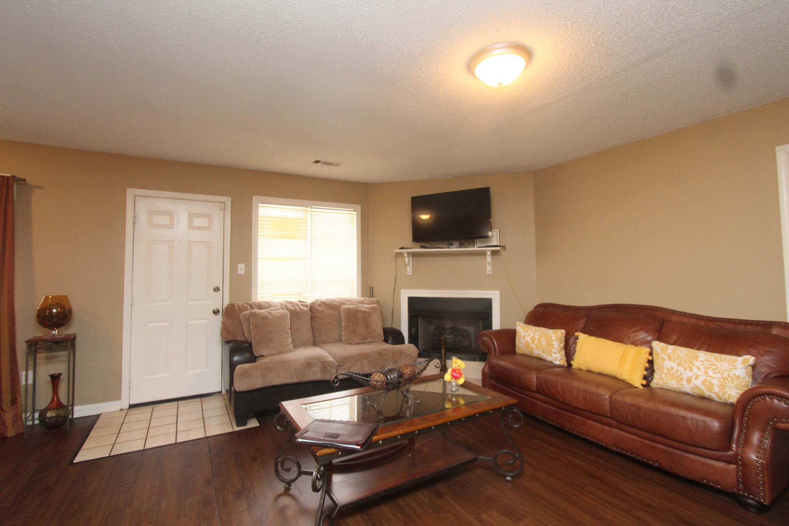 4563 Cedargreen Cove Memphis, TN 38128 - Photo 3 of 12 a living room with furniture a flat screen tv and a fireplace