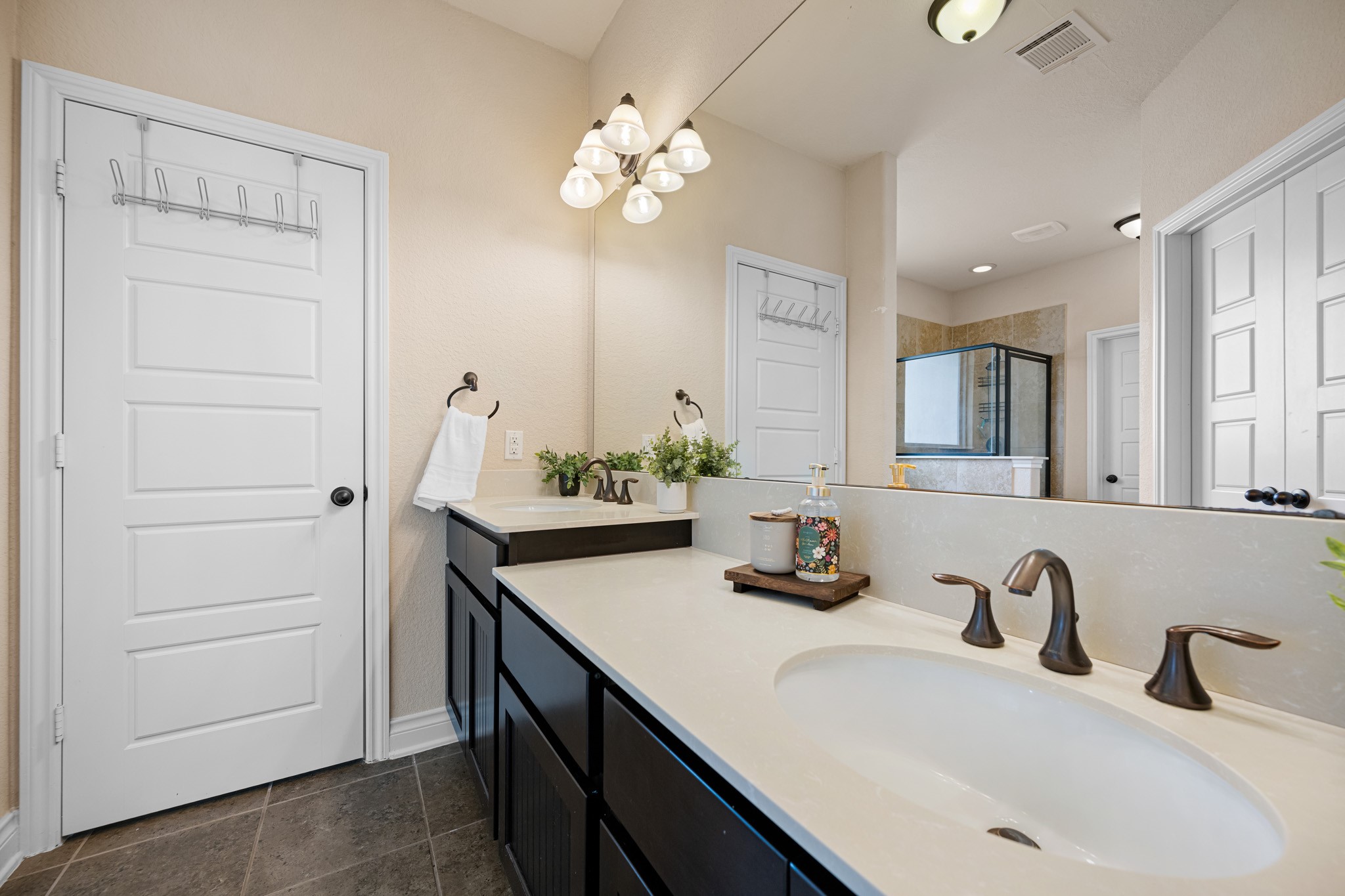 8131 Brinkmeyer Road Needville, TX 77461 - Photo 22 of 34 This primary bathroom features a modern design with a large mirror, sleek double sinks, and stylish fixtures.