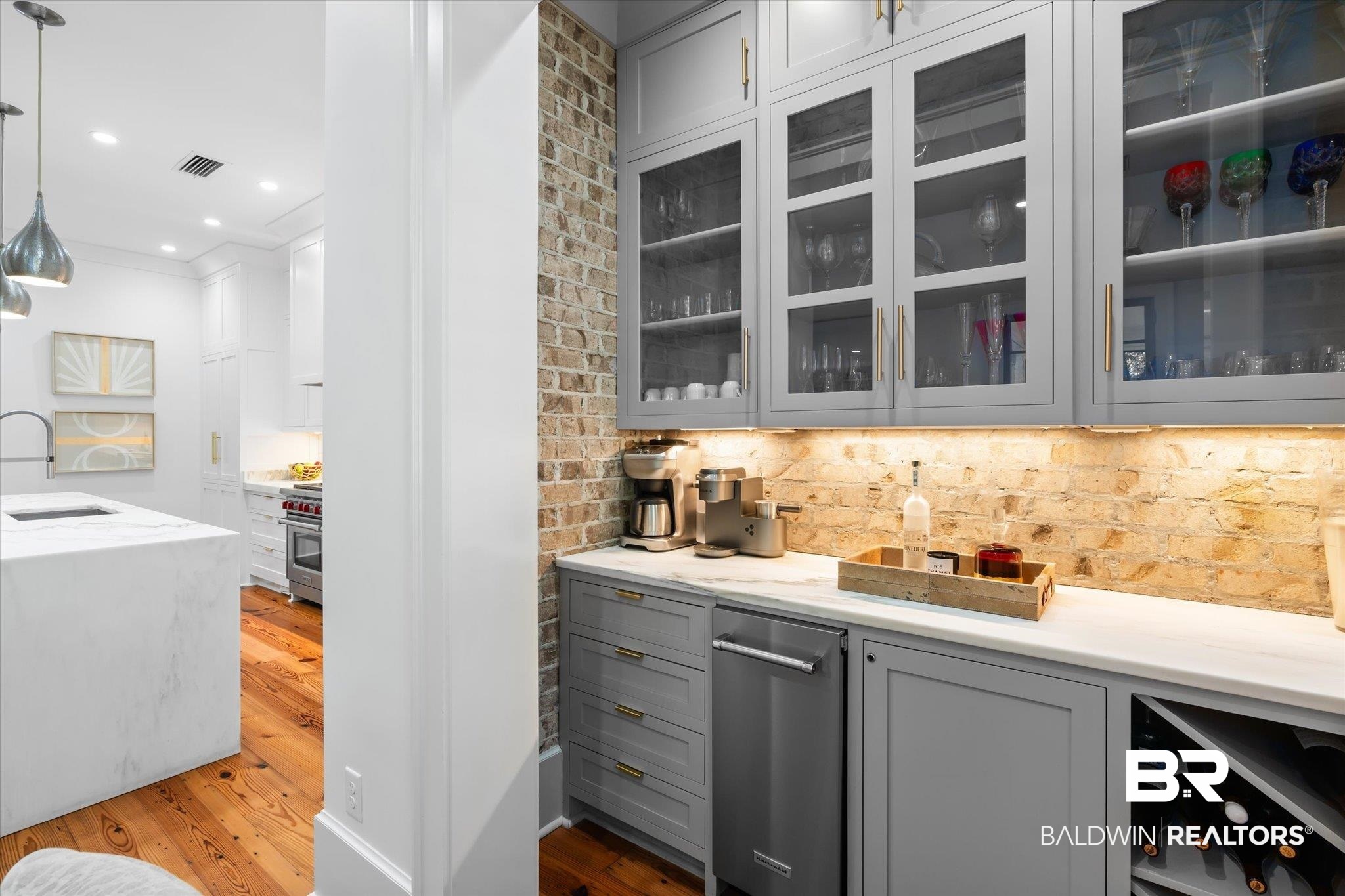 320 Long Court Mobile, AL 36608 - Photo 21 of 61 Bar with light stone counters, pendant lighting, sink, hardwood / wood-style floors, and decorative backsplash