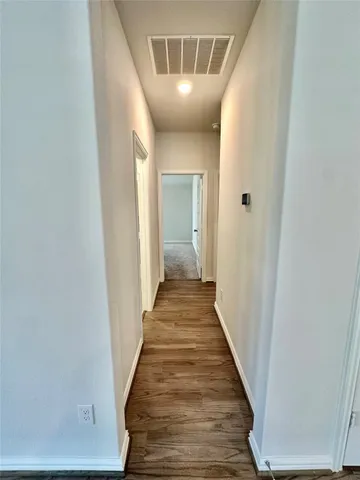 a view of a hallway with wooden floor and entryway