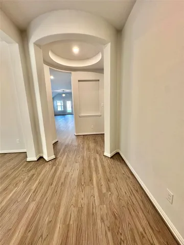 an empty room with wooden floor and entrance