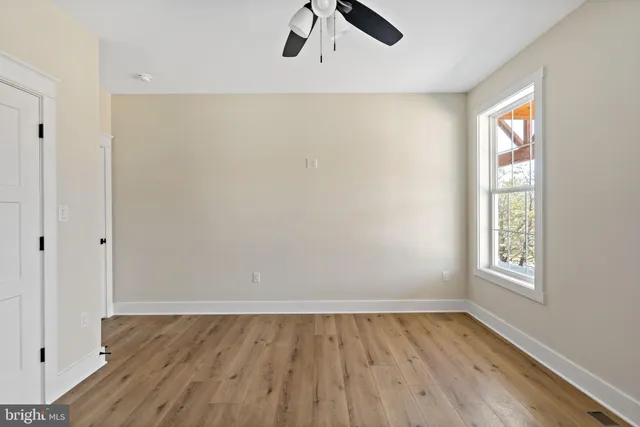 an empty room with a window and wooden floor