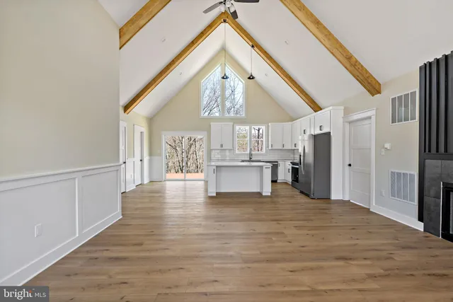 a view of a kitchen with a sink and dishwasher a refrigerator with wooden floor