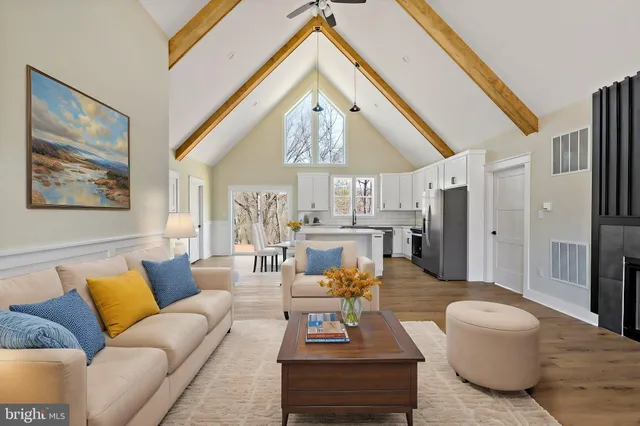 a living room with furniture a chandelier and a large window