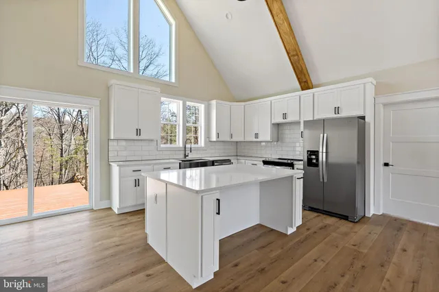 a kitchen with a refrigerator a sink and a stove top oven
