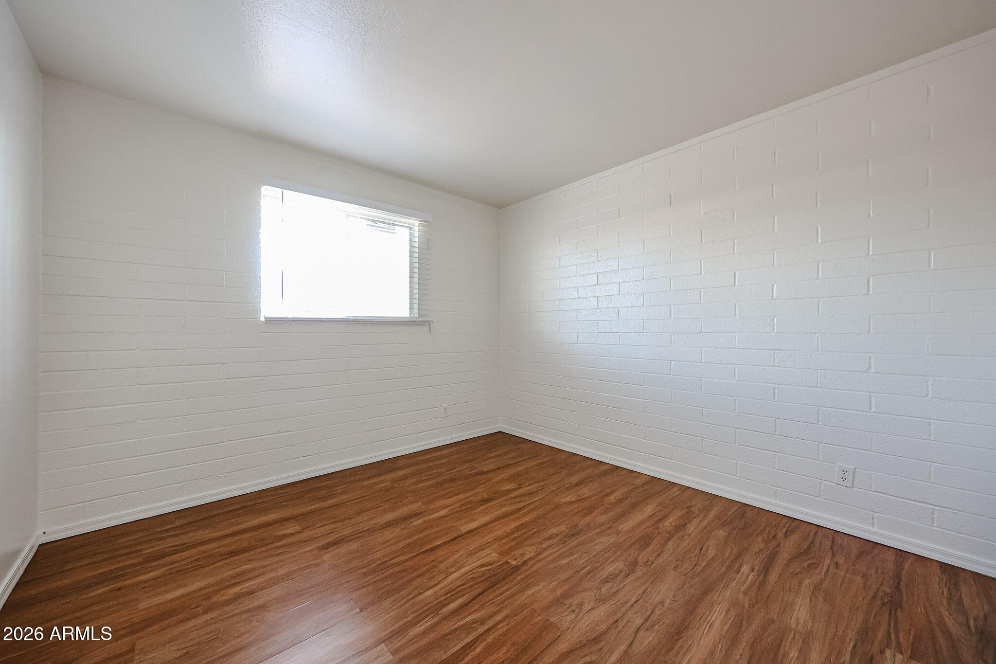 2226 West Heatherbrae Drive, Unit 4 Phoenix, AZ 85015 - Photo 15 of 17 an empty room with wooden floor and windows