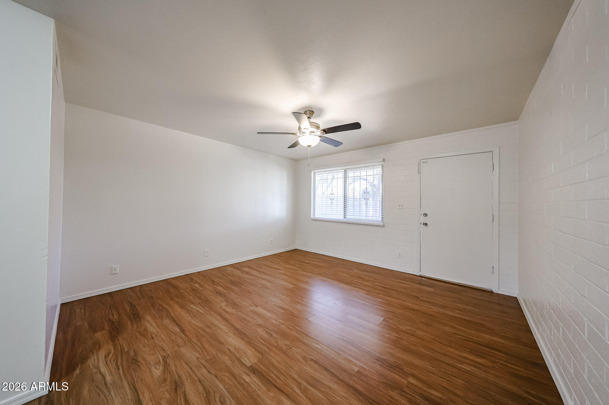 2226 West Heatherbrae Drive, Unit 4 Phoenix, AZ 85015 - Photo 7 of 17 a view of empty room with wooden floor and fan