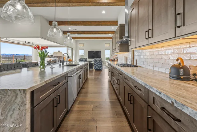 a large kitchen with stainless steel appliances kitchen island granite countertop a large counter top and a stove