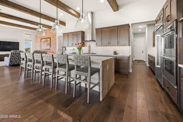 a kitchen with lots of wooden furniture appliances and wooden floor