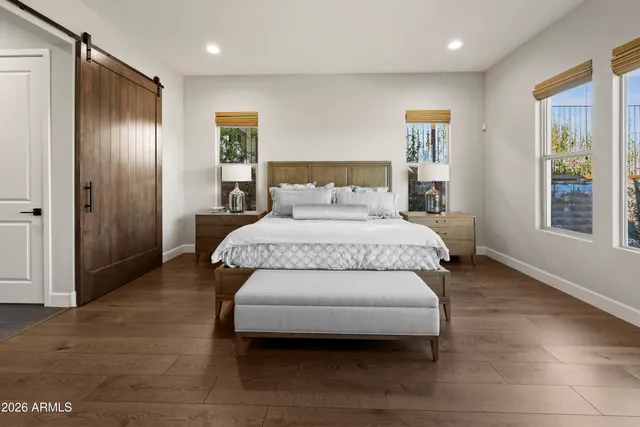 a bedroom with a large bed and a wooden floor