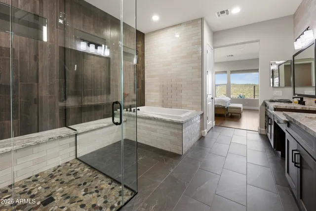 a bathroom with a tub a sink a mirror and a shower