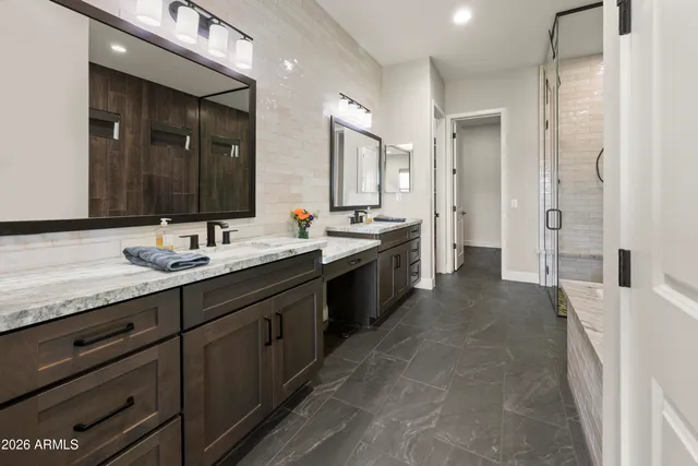 a spacious bathroom with a double vanity sink a mirror and a shower