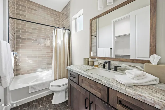 a bathroom with a granite countertop sink toilet a mirror and shower