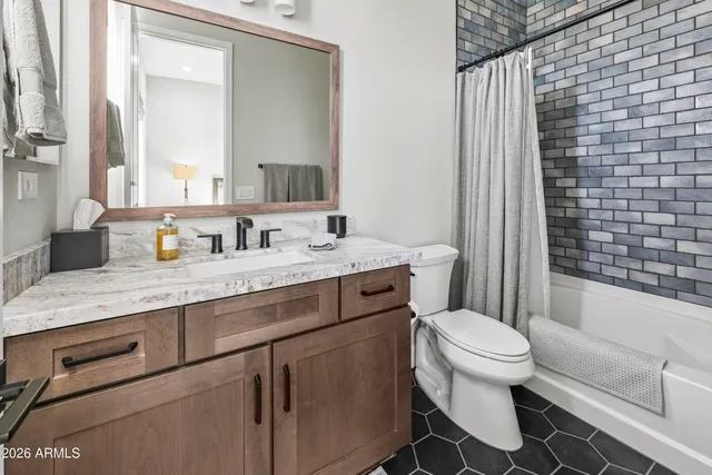 a bathroom with a granite countertop toilet a sink and a mirror