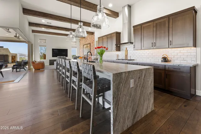 a kitchen with stainless steel appliances kitchen island granite countertop a table chairs in it and wooden floors