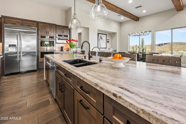 a kitchen with stainless steel appliances granite countertop a sink and a refrigerator
