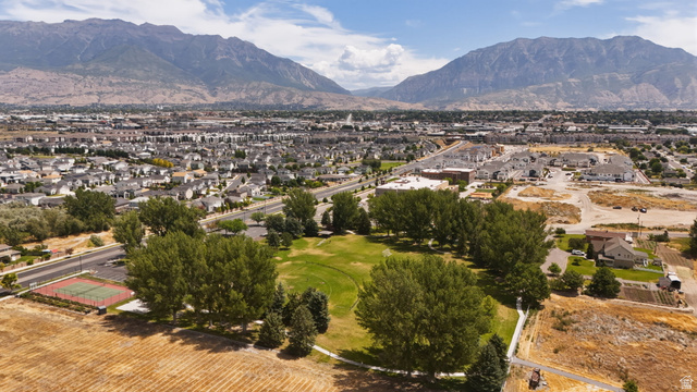 111 East Silver Oak Road Vineyard, UT 84059 - Photo 49 of 50 Expansive aerial perspective showcasing a neighborhood with diverse housing, mature trees, a manicured green space, and a red-surfaced sports court