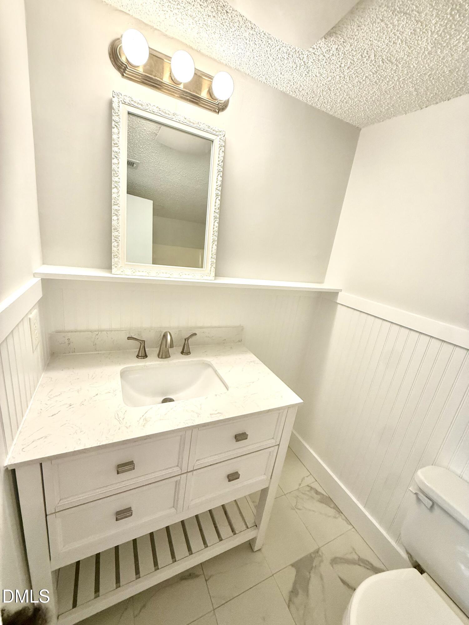 546 Pine Ridge Place Raleigh, NC 27609 - Photo 11 of 28 a bathroom with a sink vanity and a mirror