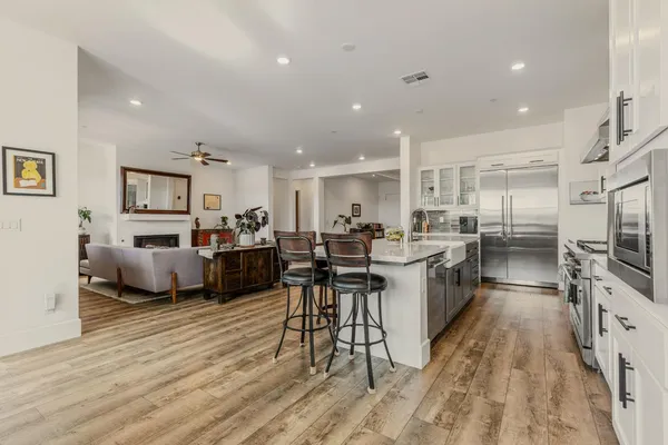 a living room with furniture a flat screen tv and kitchen view