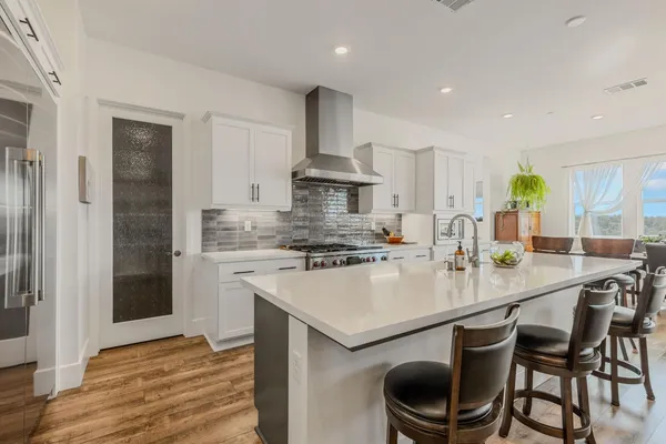 a kitchen with stainless steel appliances granite countertop a stove a sink a refrigerator and a granite counter tops