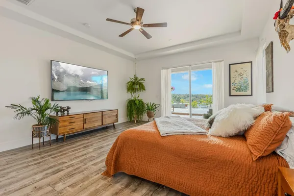 a bedroom with a balcony a bed and a flat screen tv