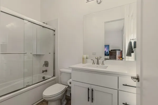a bathroom with a sink toilet vanity and shower