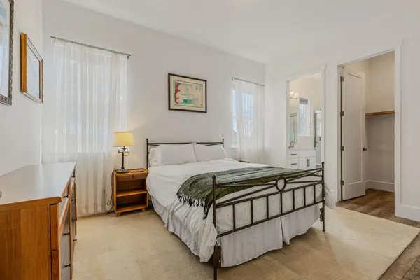 a bed sitting in a bedroom next to a bathroom