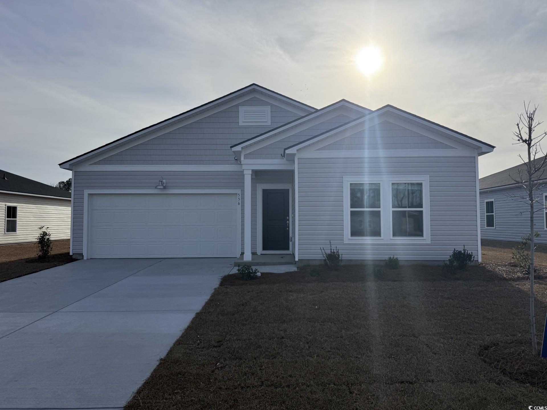 Ranch-style home with concrete driveway and an attached garage