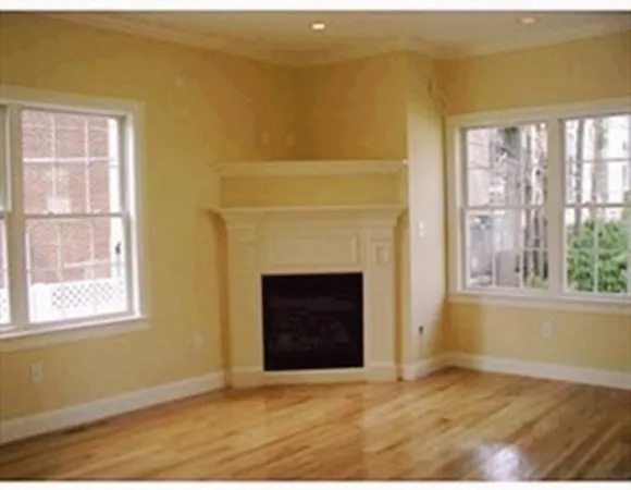 a view of an empty room with a fireplace and a window