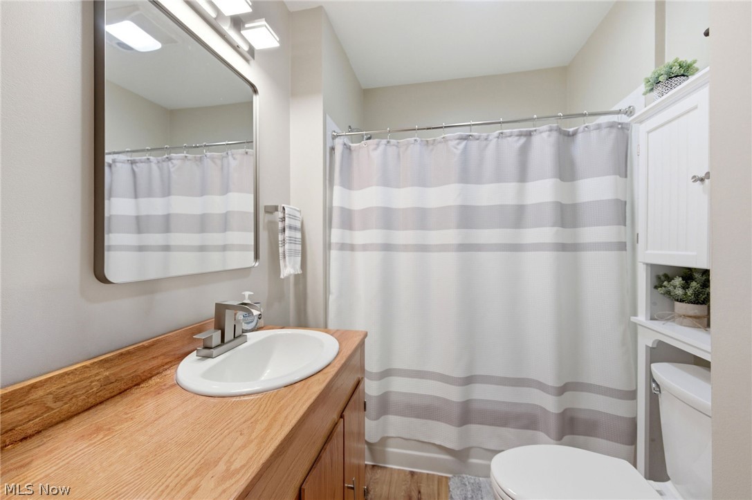 233 Sunset Road Avon Lake, OH 44012 - Photo 22 of 50 Bathroom featuring a wood-finish vanity with an integrated sink, a large wall-mounted mirror, and a tub