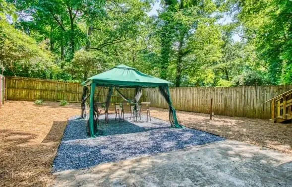 a backyard of a house with barbeque oven table and chairs
