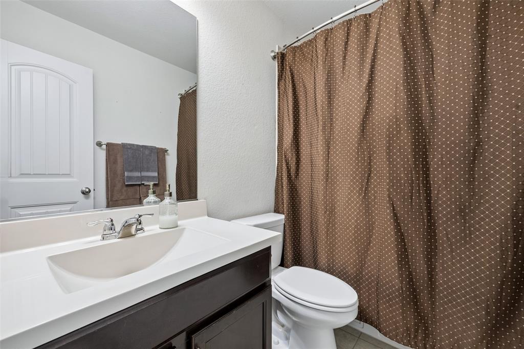 406 Madrone Lane Princeton, TX 75407 - Photo 19 of 30 Hall bathroom featuring a white integrated sink, chrome faucet, and dark wood vanity with cabinet storage