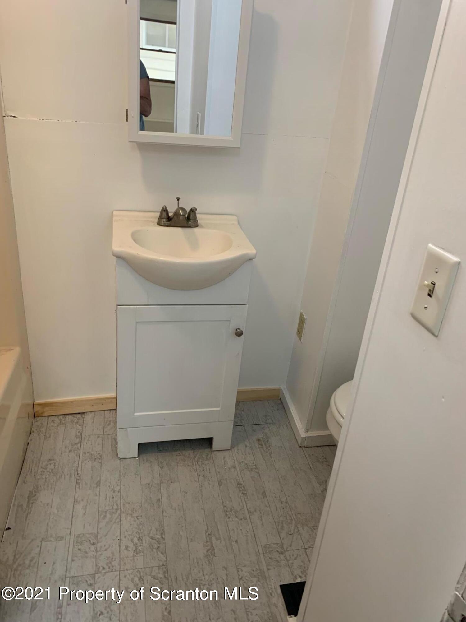 42 Fallbrook Street Carbondale, PA 18407 - Photo 39 of 41 a bathroom with a sink a toilet and mirror