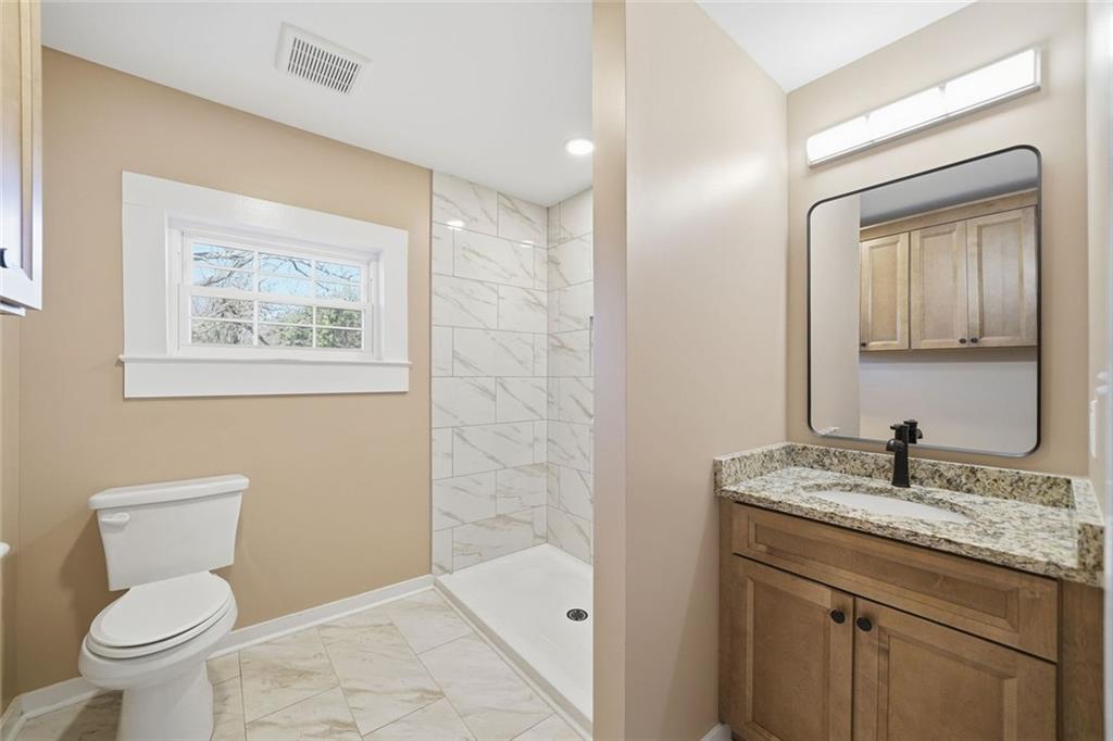 3418 Refuge Road Jasper, GA 30143 - Photo 21 of 55 a bathroom with a granite countertop sink a toilet and a mirror