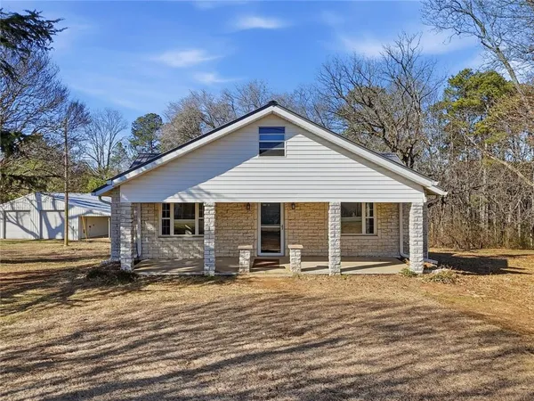 a view of a house with a yard and wooden fence