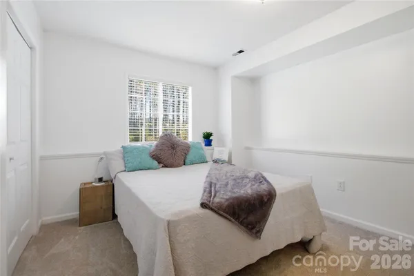 a bed sitting in a bedroom next to a window