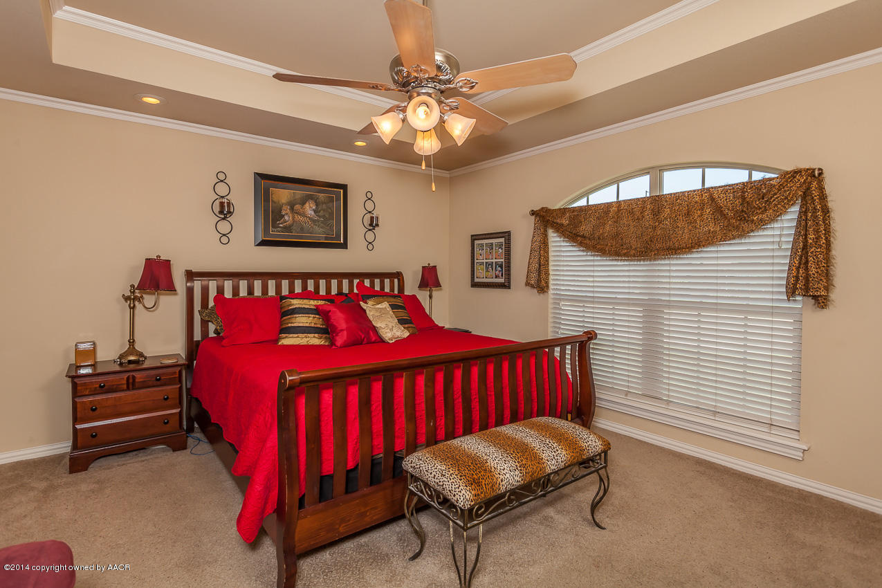 5811 South Rusk Street Amarillo, TX 79118 - Photo 11 of 22 a bedroom with a bed and a chandelier